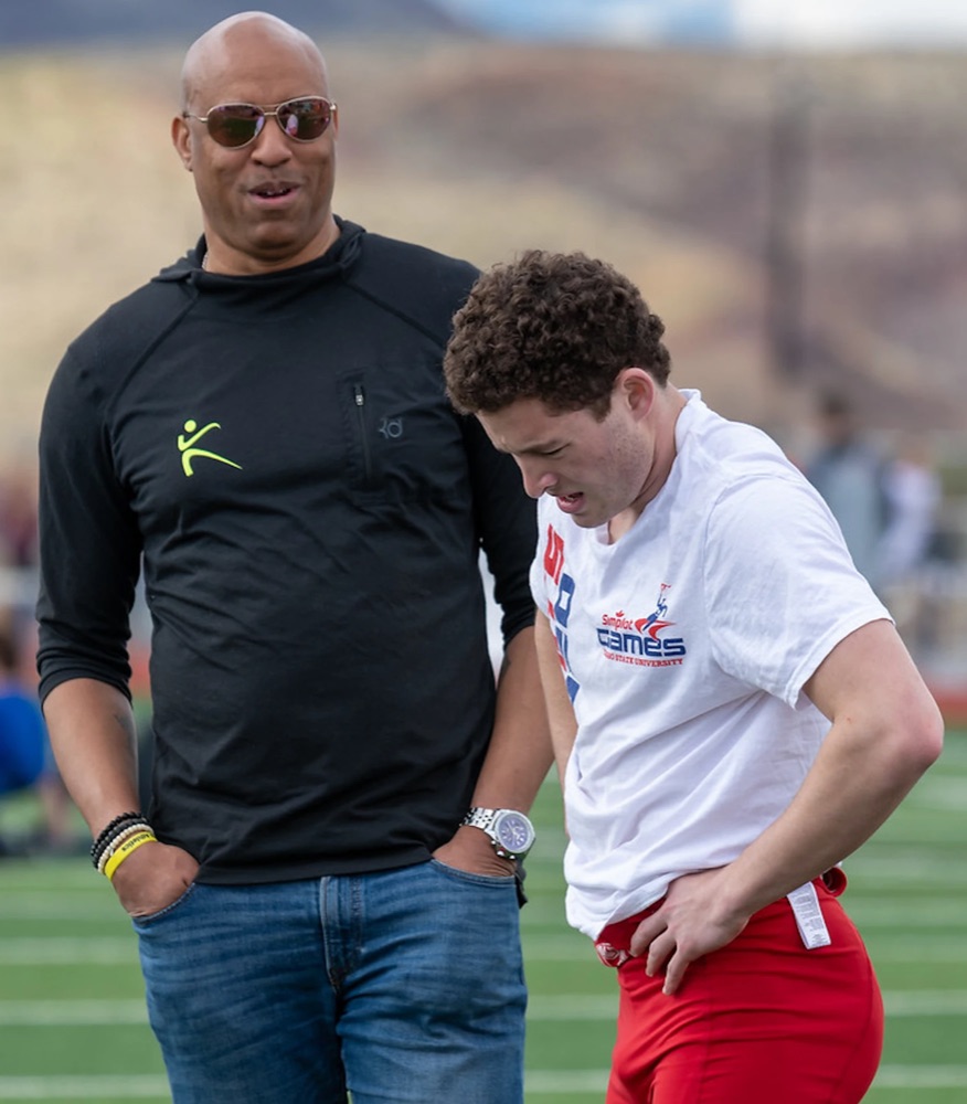 Head coach Sean Maye with an athlete on the track